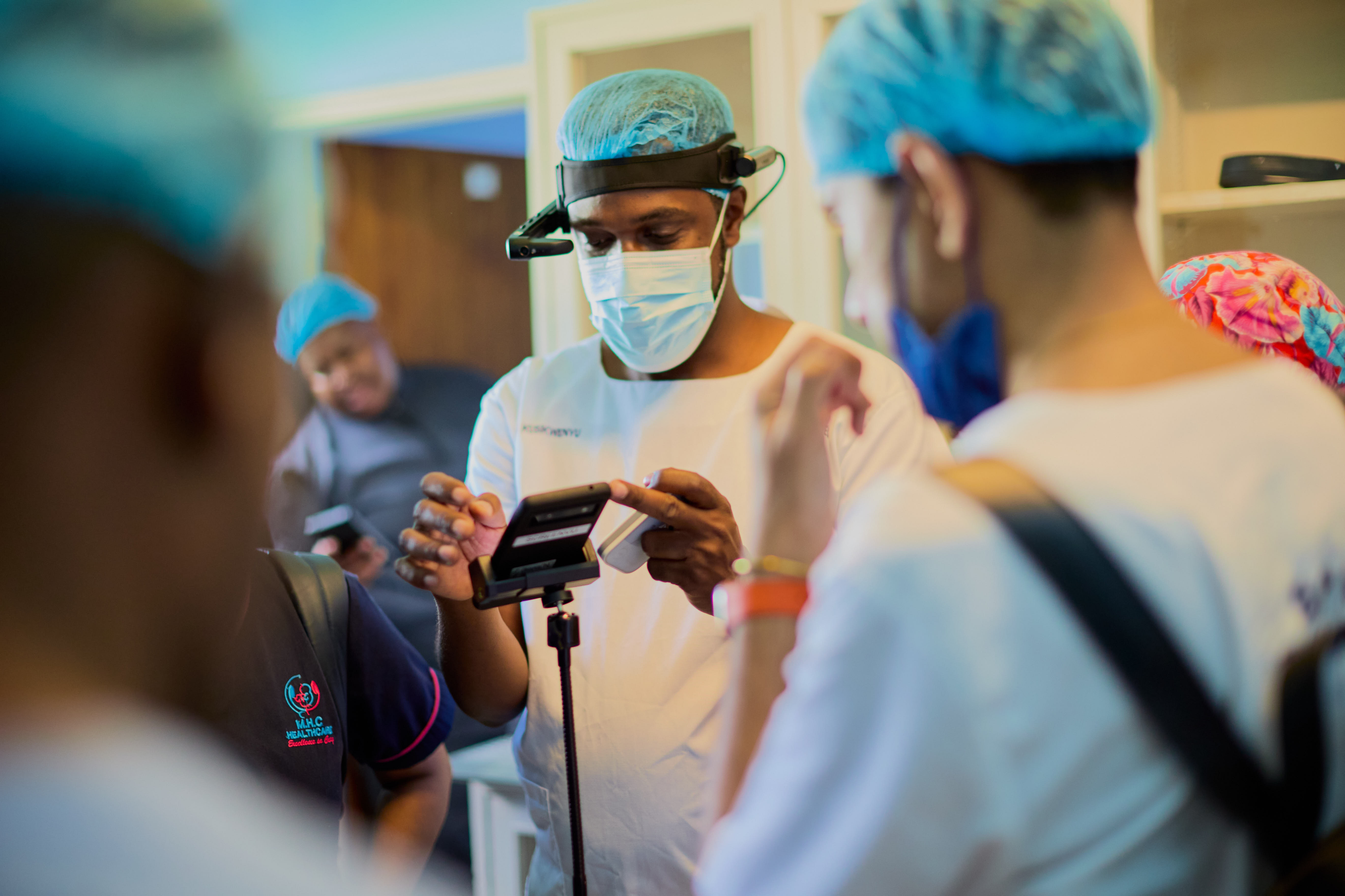 Healthcare provider demonstrating medical device to colleagues in surgical theatre